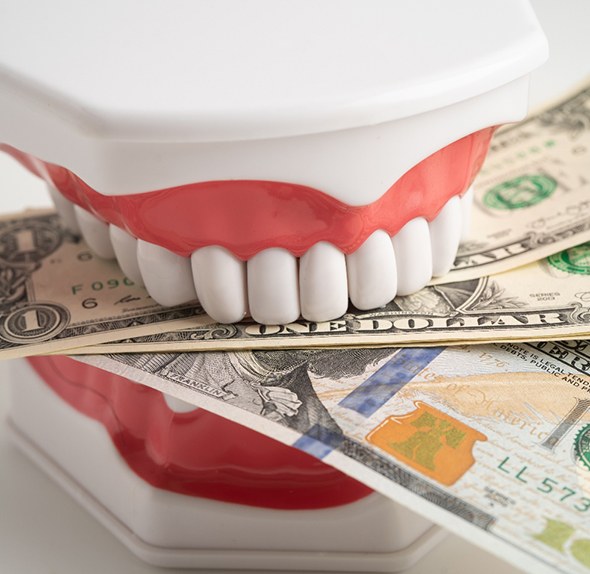 Fake teeth biting dollar bills