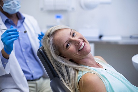 a person smiling and sitting in a dental chair