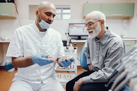 A dentist and patient discussing dentures in Cottonwood Heights