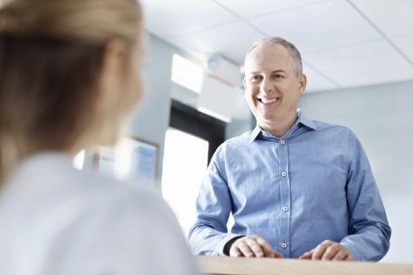 Man smiling after turning in dental insurance information