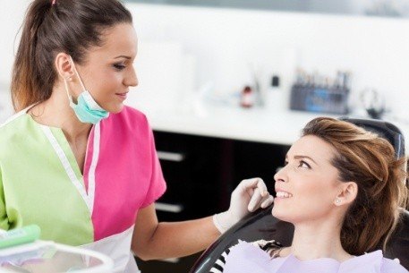 Woman talking to dental team member during her regular dental visits