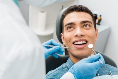 Man receiving dental cleaning and screening
