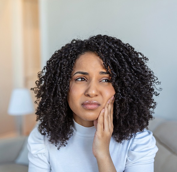 Woman experiencing toothache at home