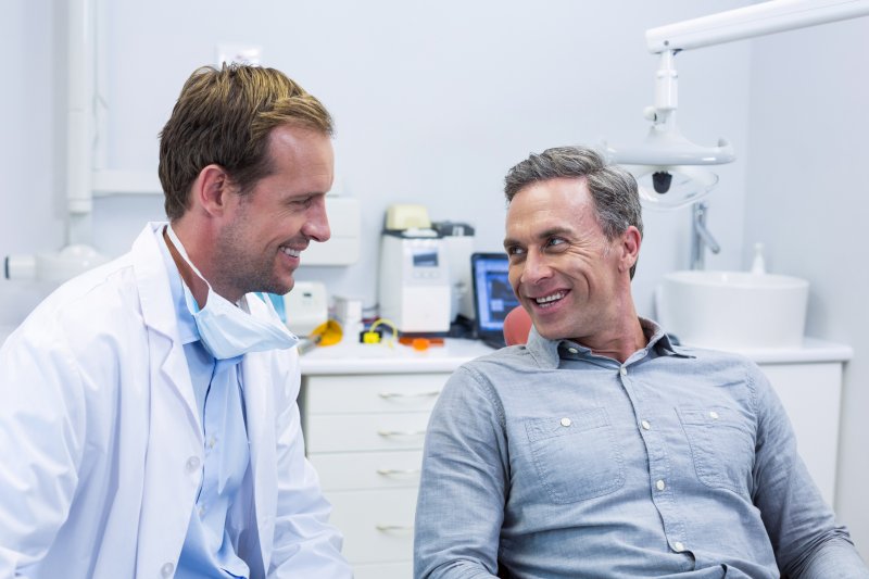 dentist answering questions about lifespan of dental implants 
