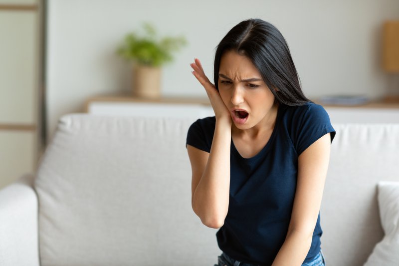 A woman in pain, waiting for an emergency dentist appointment