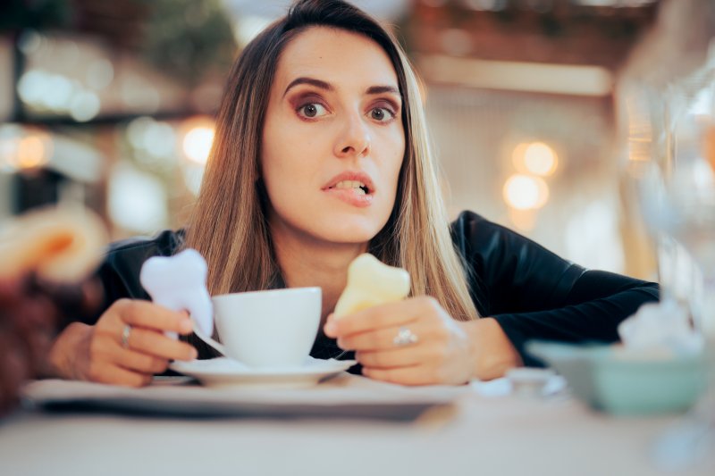 woman with a cup of coffee and a white and dull colored tooth