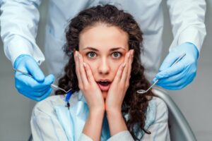 Woman making scared expression in the dentist's chair.