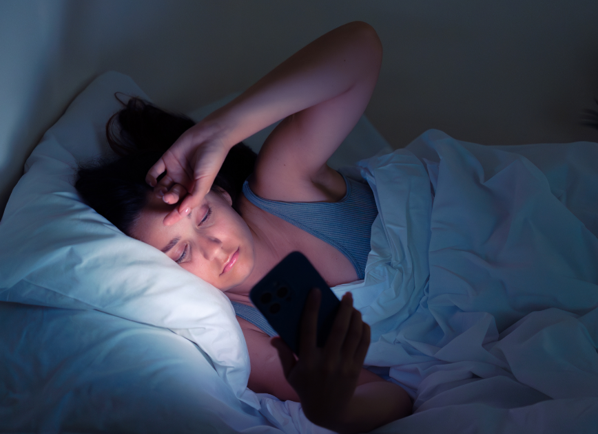 Woman lying in bed with phone