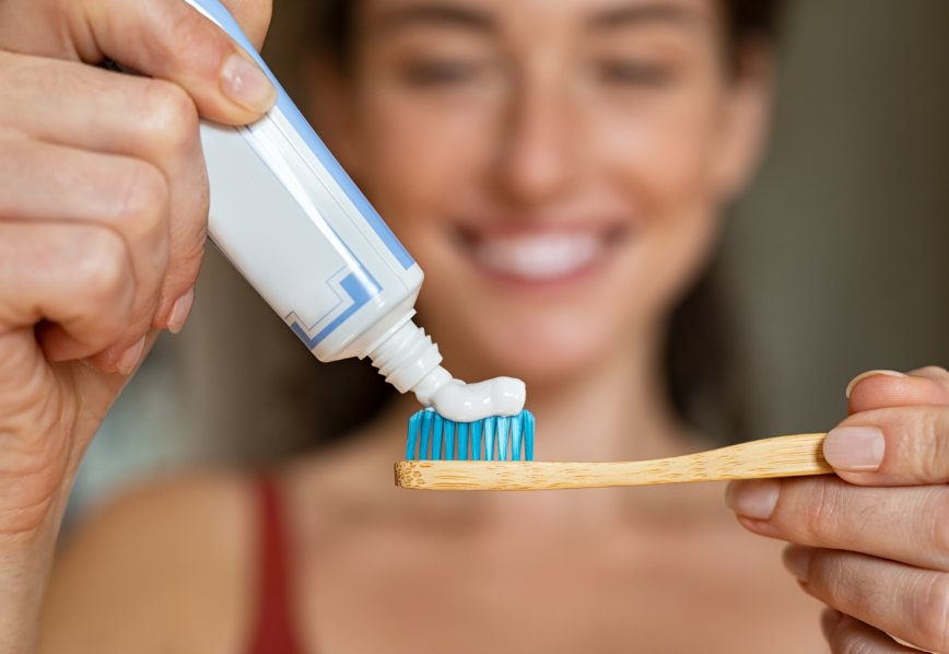 Woman putting toothpaste on brush